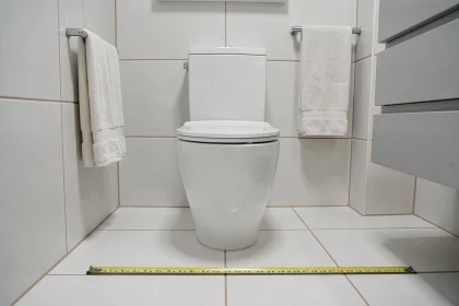 WC suspendu dans une salle de bain compacte avec mètre ruban au sol montrant l'espace disponible devant et sur les côtés